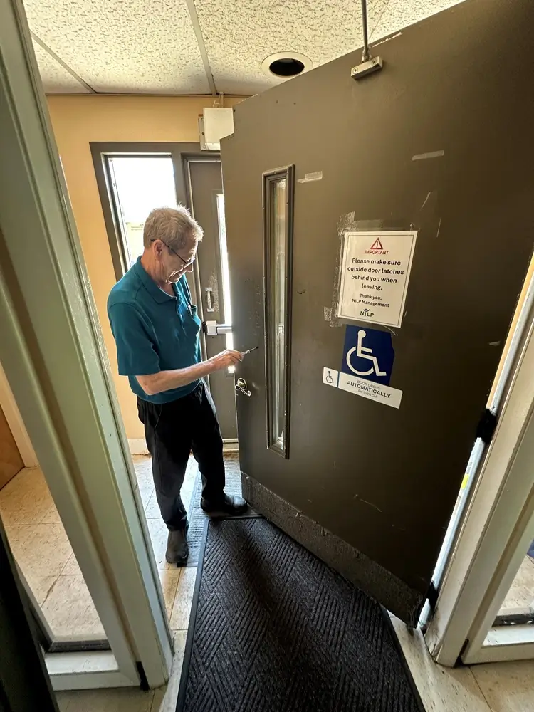 Jim Lyons evaluating the hardware and accessibility features of an entrance door.